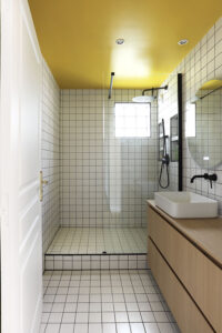 projet, rénovation, décoration, architecture, architecture d'intérieur, salle de bains, salle d'eau, matériaux, rangements, meuble, sur mesure, bois, jaune, noir, blanc, graphique, carreau, 10x10, plafond, mon oeil dans la déco, val de marne, vincennes